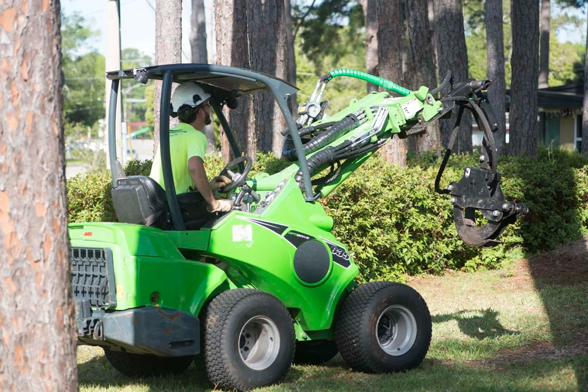 Compact articulated loader clearing brush — tree service in Jacksonville, FL by Jax Tree Removal