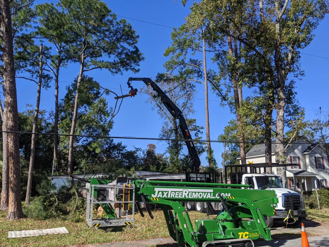 Crane grapple lifting a cut limb — crane tree removal in Jacksonville, FL by Jax Tree Removal