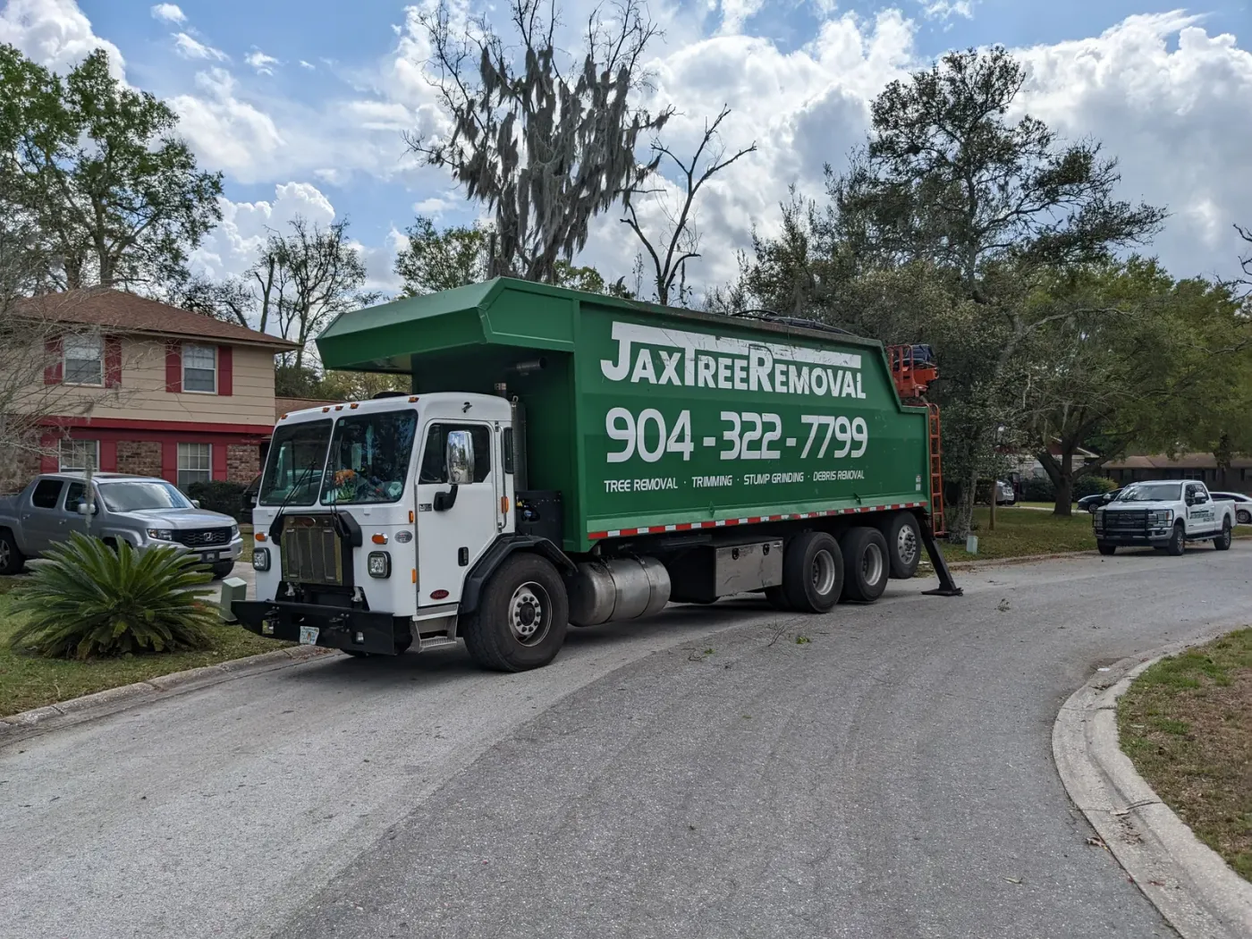 Branded JaxTreeRemoval.com truck on a Jacksonville street — tree service in Jacksonville, FL by Jax Tree Removal